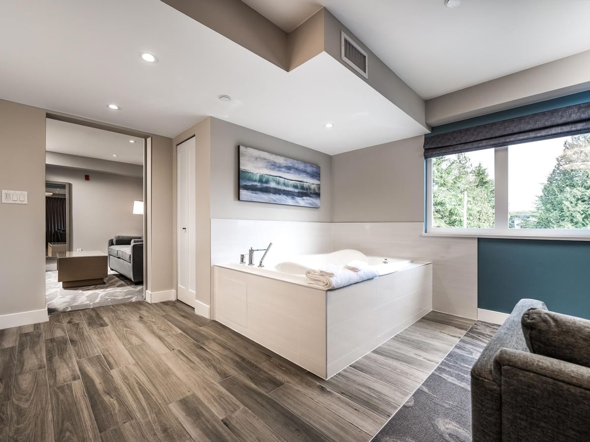 View of the jetted tub with living room in the background