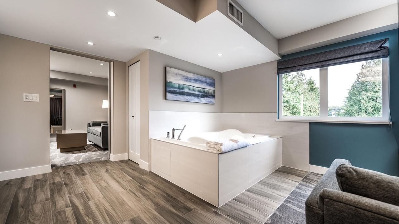 View of the jetted tub with living room in the background