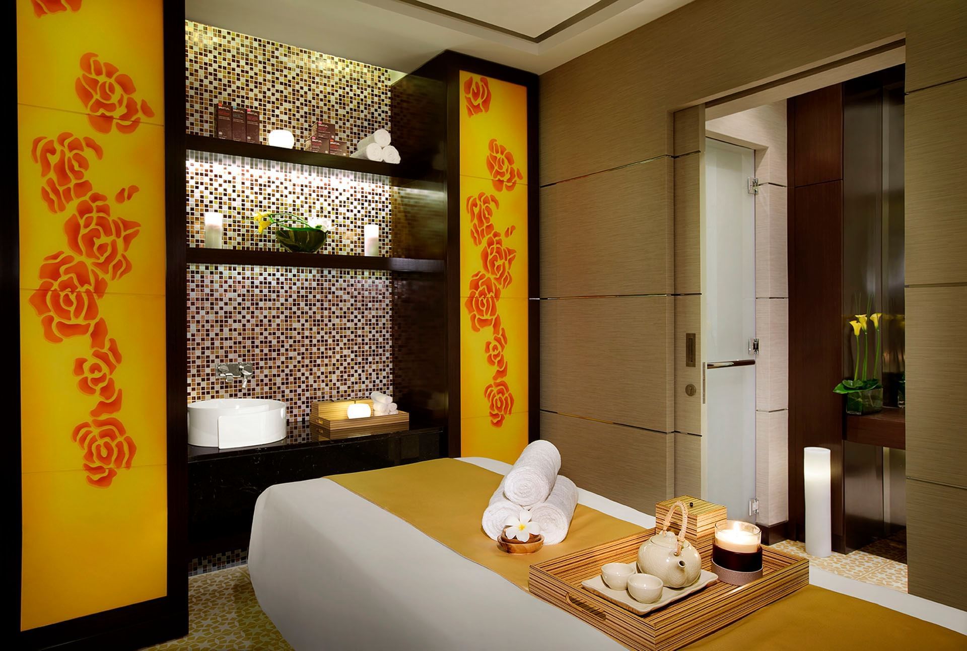 Elegant spa room with massage table, warm lighting, and floral decor in Spa Jardin at DAMAC Maison Cour Jardin
