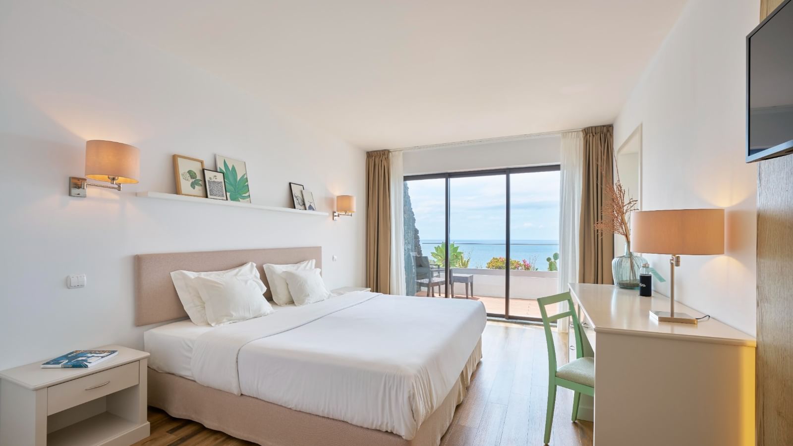 TV and workspace facing the cozy beds in the Junior Suite with wooden flooring at Caloura Hotel Resort