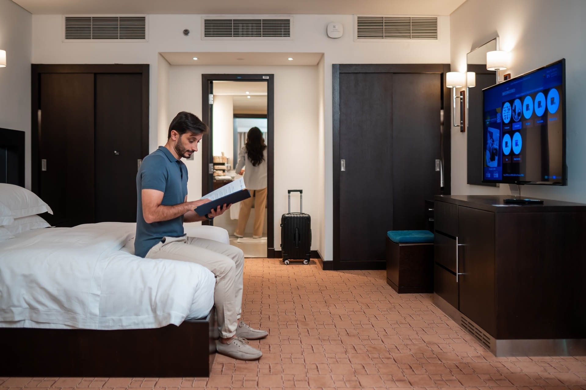 A man reading a book in a room - Dubai International Hotel
