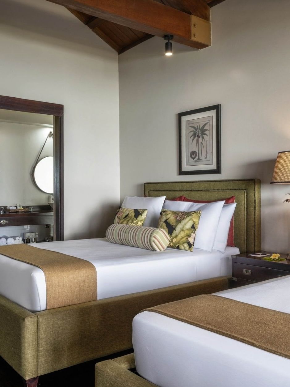 Twin bedroom with olive green bed frames and views into attached bathroom in Erakor Residence at warwick le lagon-vanuatu