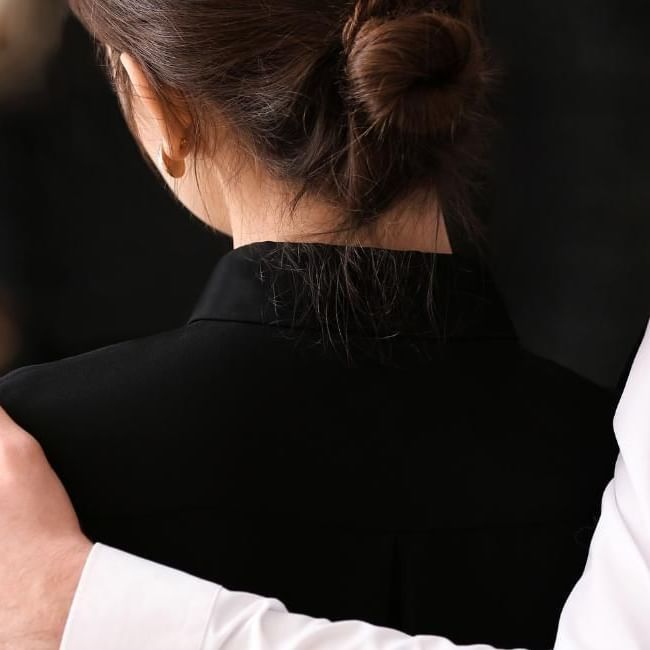 Man providing comfort to women during a wake, featuring our article on 
