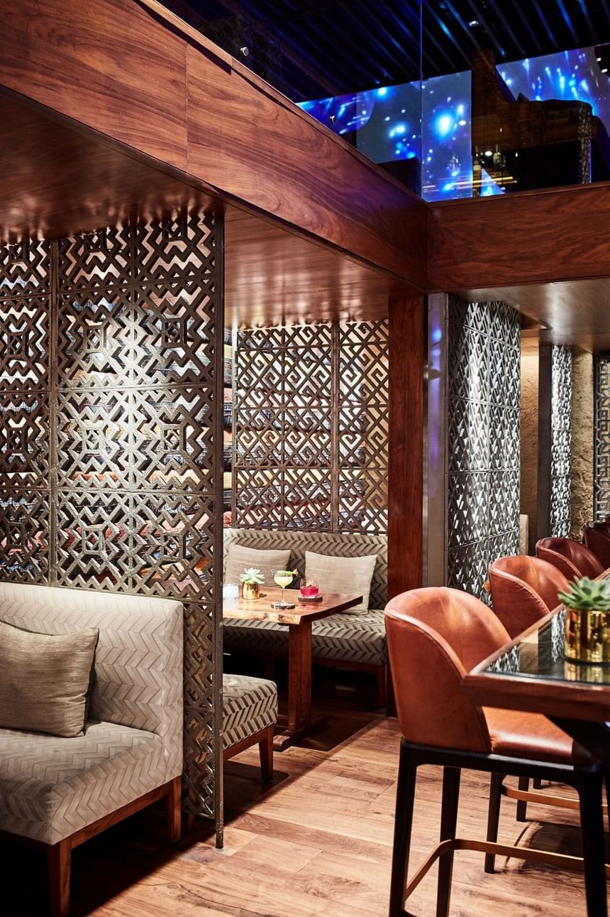 2 Lam Son interior featuring intricate wooden screens, cozy seating, and a modern bar at Park Hyatt Saigon