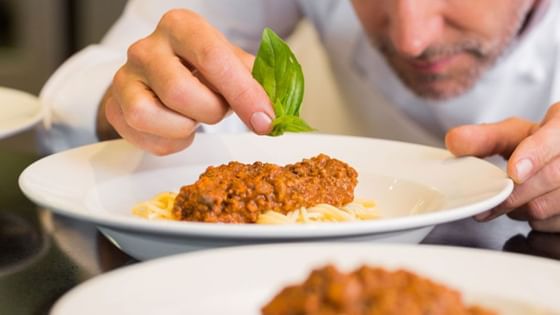 Closeup of a chef garnishing a dish at Amara Hotel Shanghai