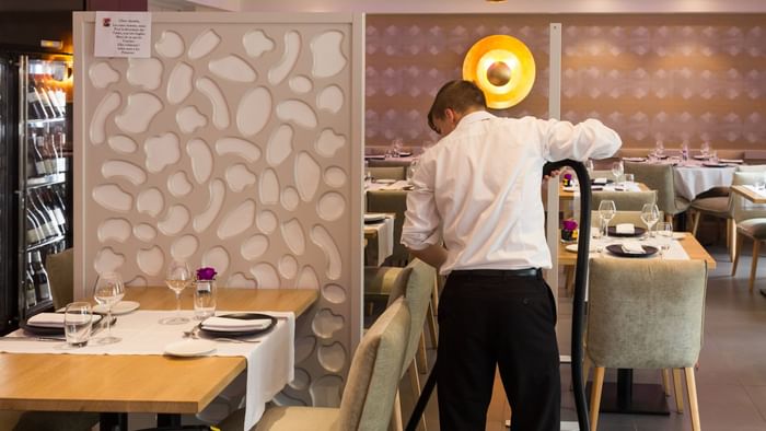 A waiter cleaning the dining room at Hotel Le Lion d'Or