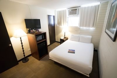 A bed, TV & mini fridge in Boutique Queen at Stay Hotel Waikiki