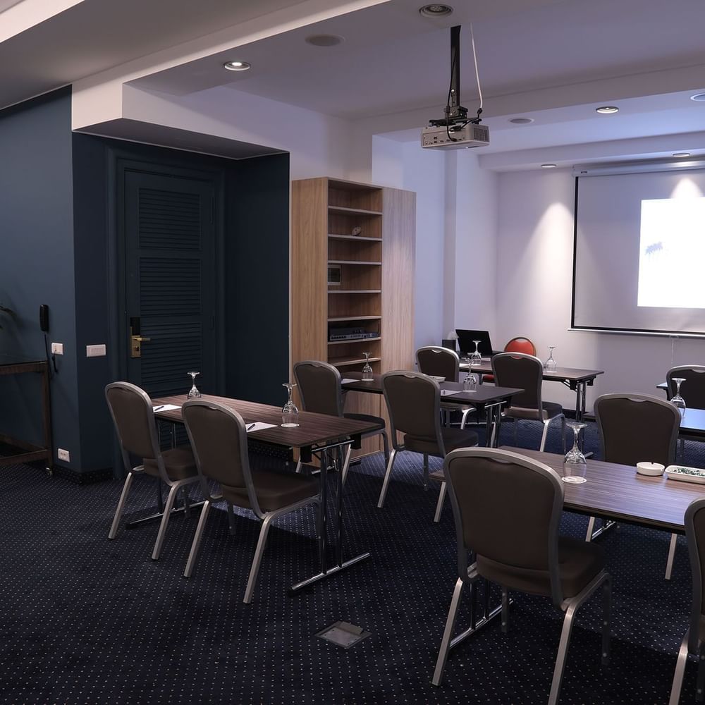 Classroom-style seating facing a projector screen beside the refreshment station in Gallery at Warwick Palm Beach Hotel