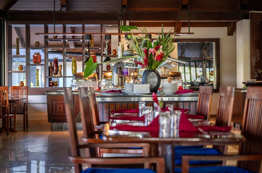 Dining area with wooden chairs and set tables at Warwick Le Lagon - Vanuatu.