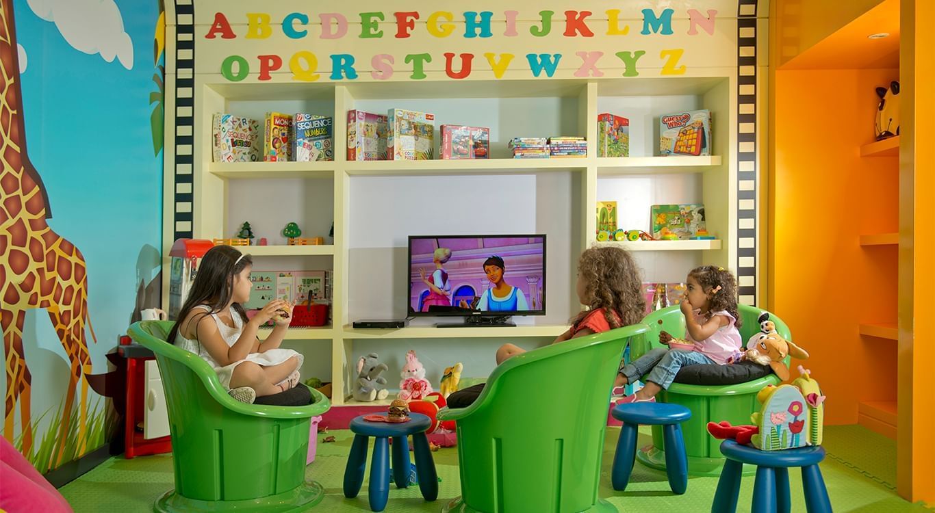 Kids watching TV in the Kids Club with toys and alphabet decor at DAMAC Maison Mall Street