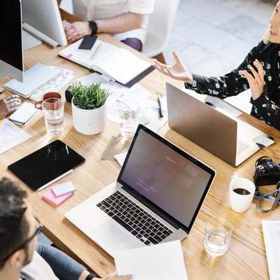 A meeting table with laptops & documents at Originals Hotels