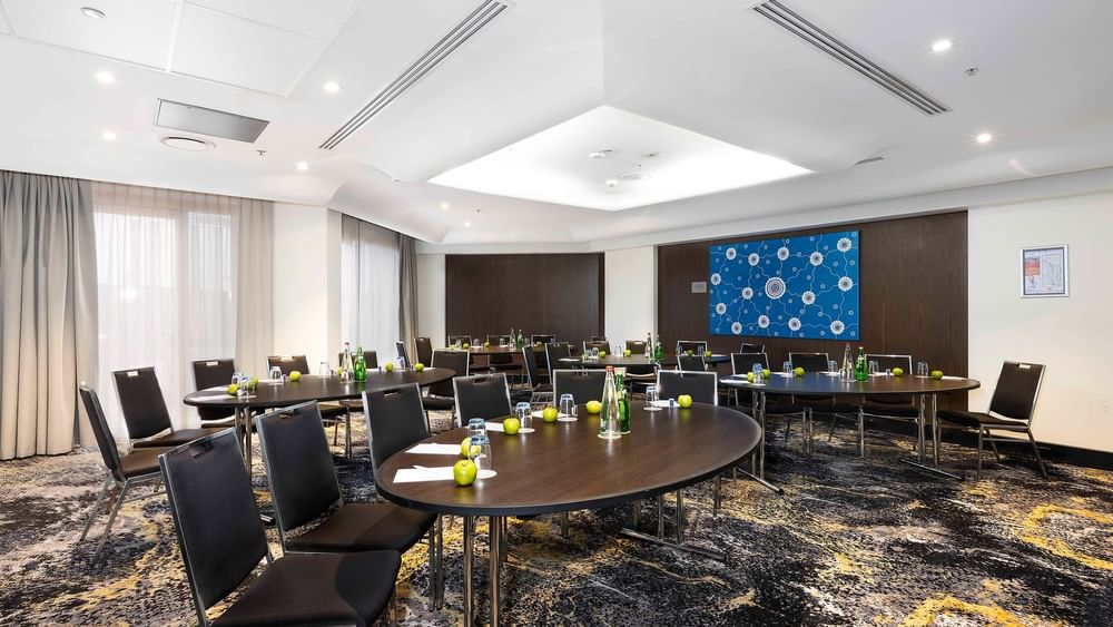 Table set-up with carpeted floors in The Yarra Room at Novotel Sydney on Darling Harbour