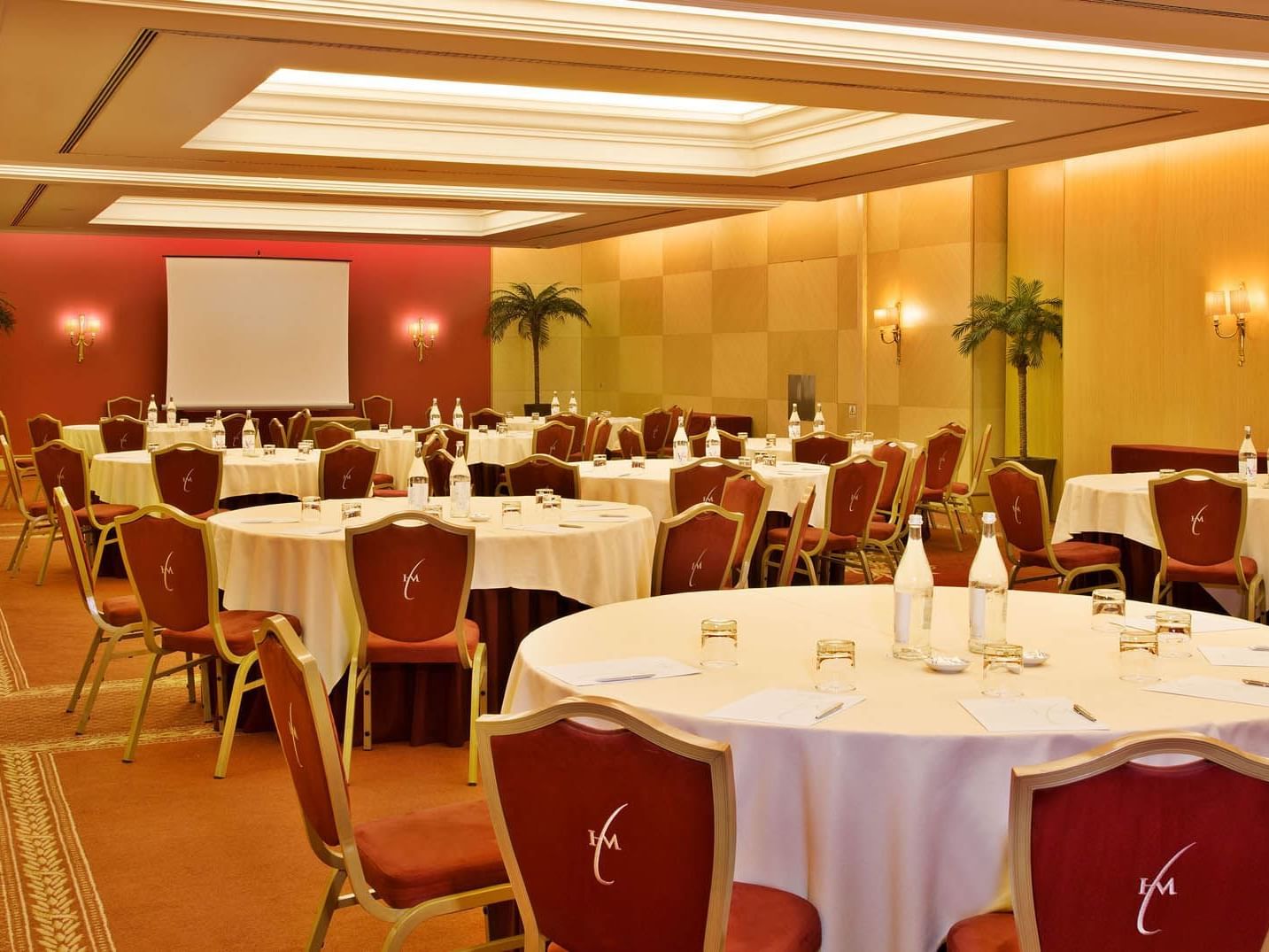 Room with round tables and red chairs at Hotel Cascais Miragem