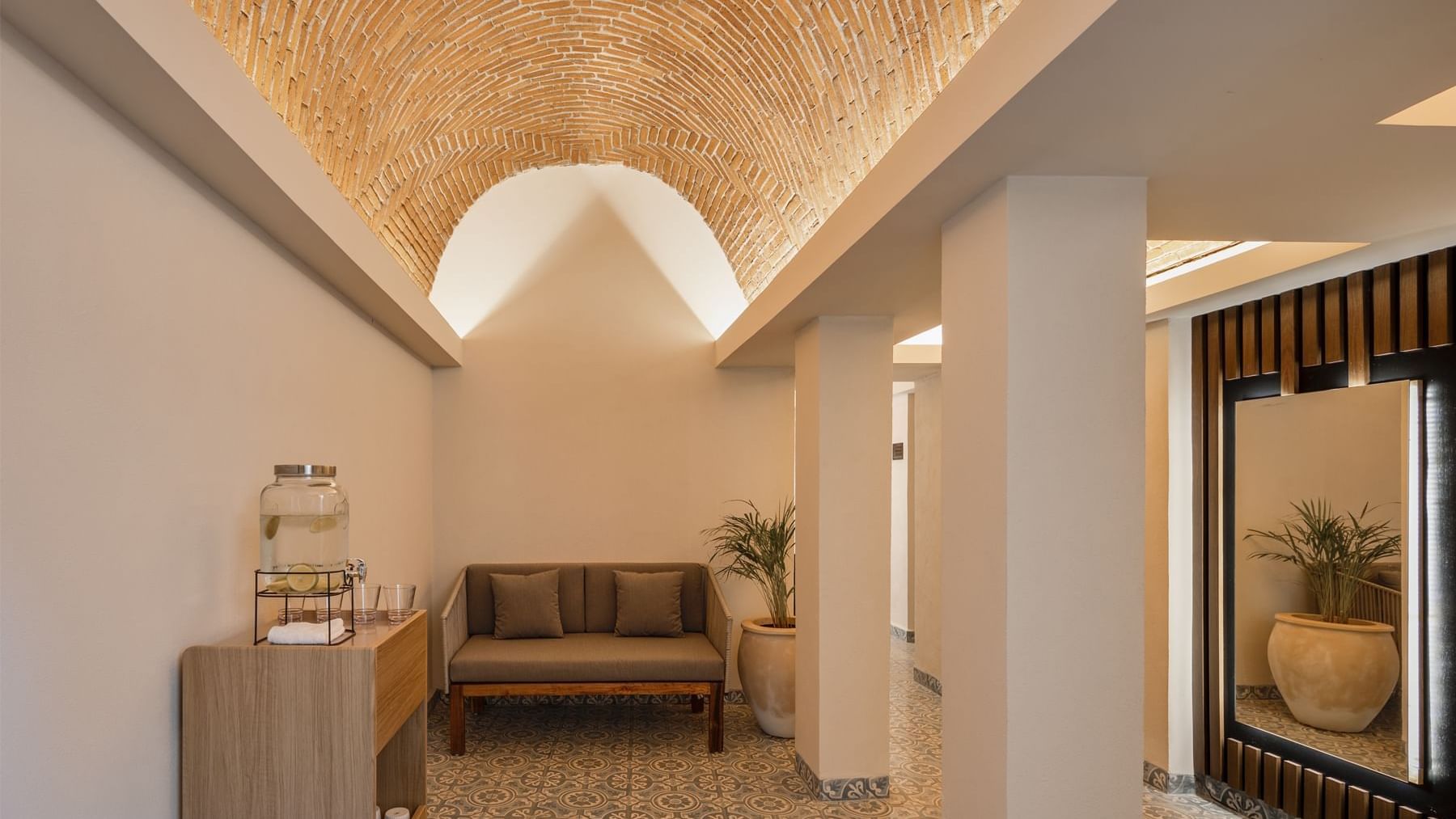 Hallway at Fiesta Americana, featuring a stunning arched brick ceiling, comfortable seating, and patterned floor tiles