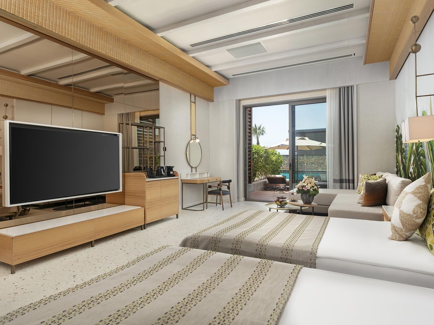 TV & seating area by the beds in Lagoon Swim-up Room at Cullinan Belek