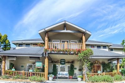 Front of the main lodge with balcony, seating area and plants