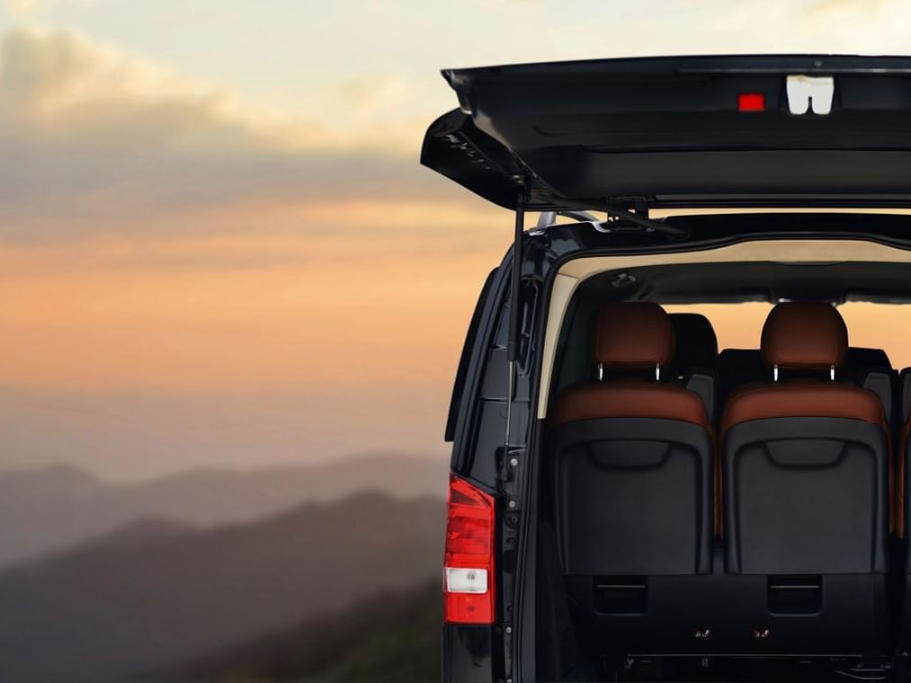 Open trunk of a parked van with mountain view at Golf Hotel Punta Ala