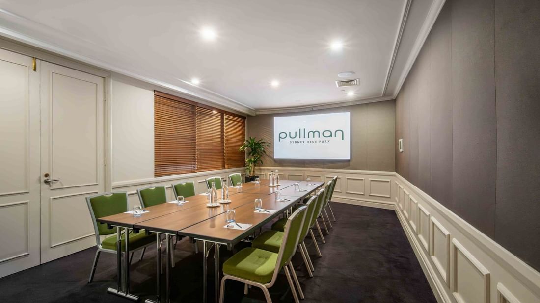 Boardroom set-up with projector screen in Dalley Room at Pullman Sydney Hyde Park