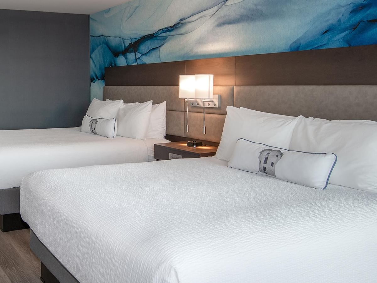 Two queen beds with white linens and decorative pillows in a room at Coast Bastion Hotel in Nanaimo.