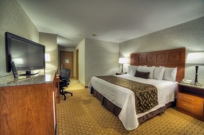 Cozy King Suite at Moab Valley Inn with a king bed, work area, TV, and warm lighting for a relaxing stay