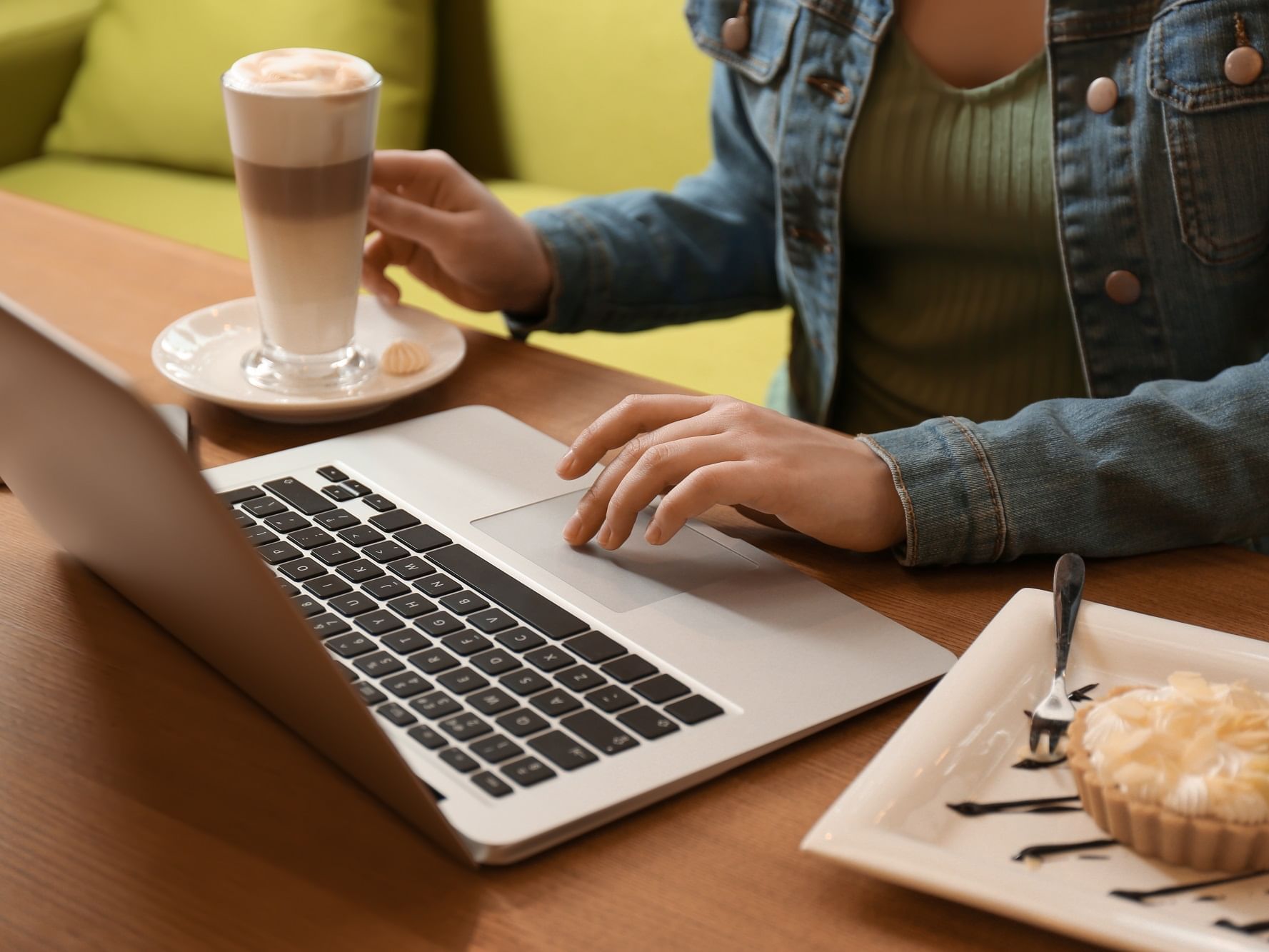 A Girl on a laptop while having a milkshake at Originals Hotels