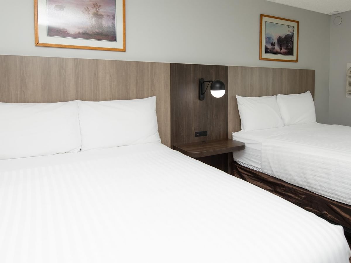 Coast Two Queens room with two queen beds, wood headboards and framed artwork.