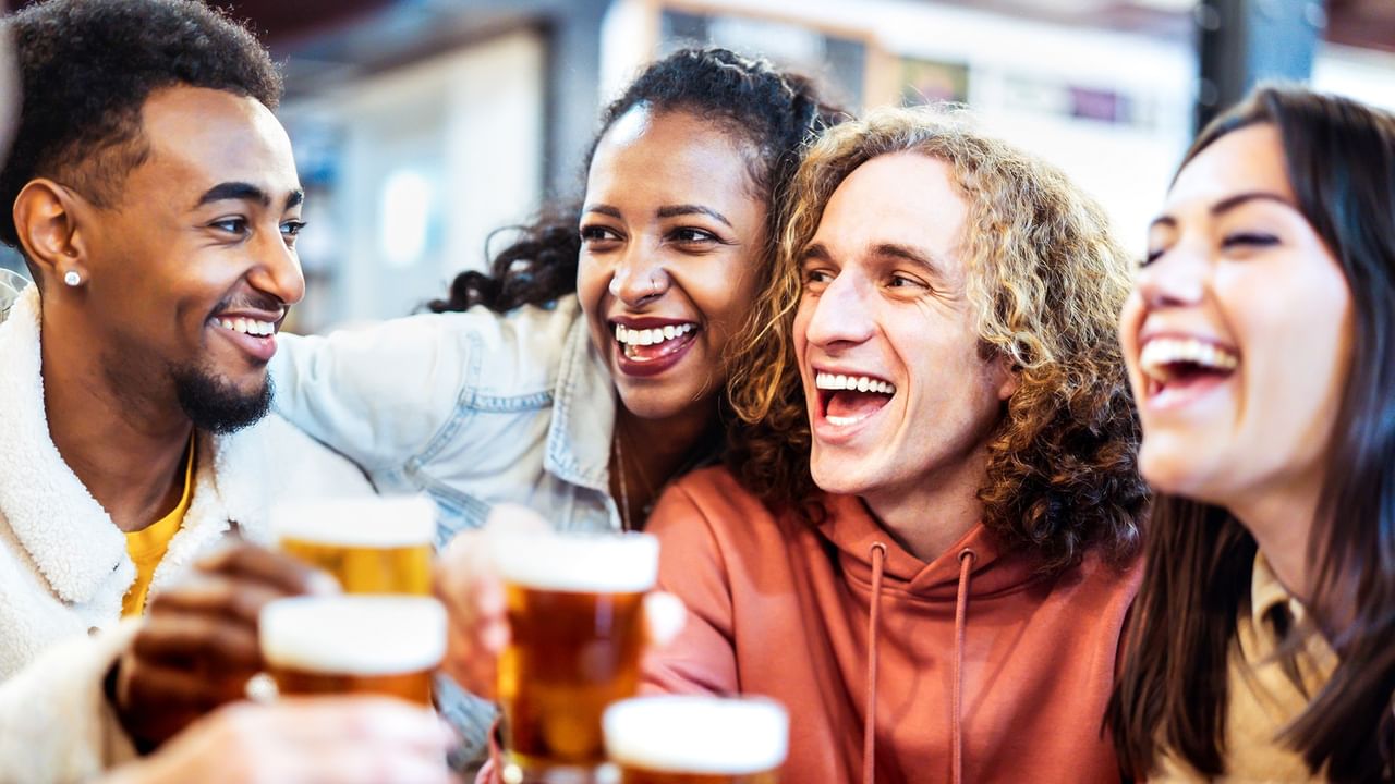 a group of friends drinking and toasting together happily