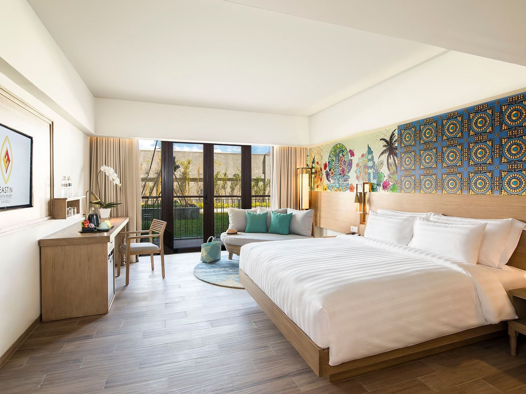 Cozy bed, lounge & working table in Deluxe Room at Eastin Ashta Resort Canggu