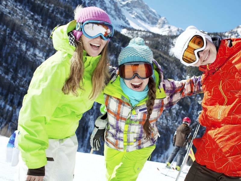 Three girls laughing and skiing on mountain