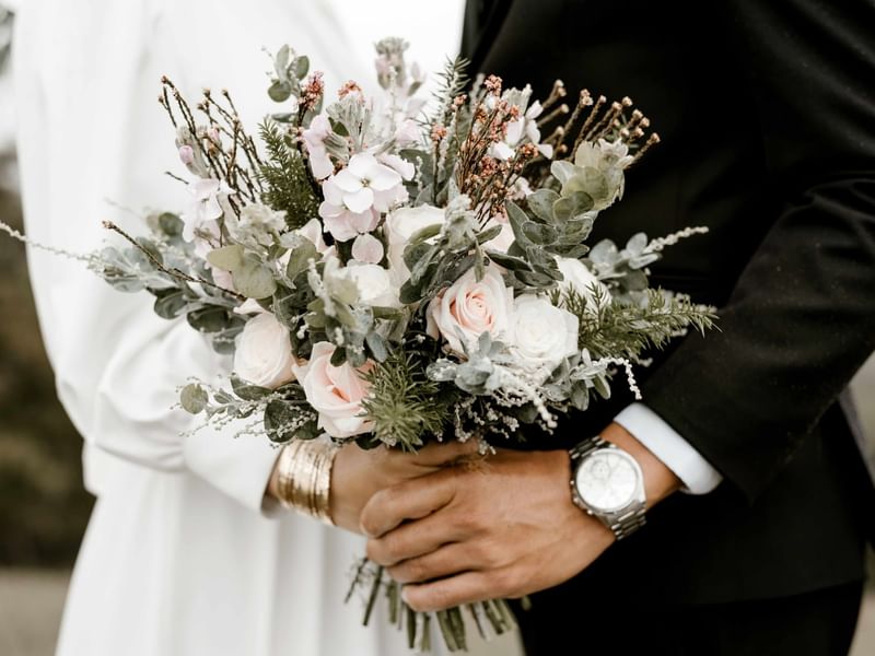A couple holding a flower bouquet at Fullerton Group