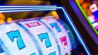 Machine à sous avec trois rouleaux affichant tous trois le chiffre 7.