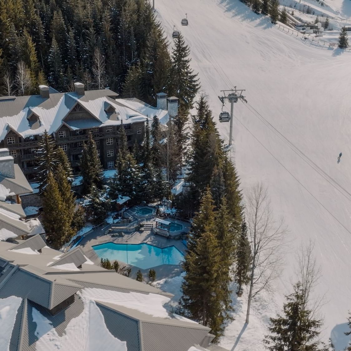 Aerial view of Blackcomb Springs Suites & outdoor pool with skiing slopes