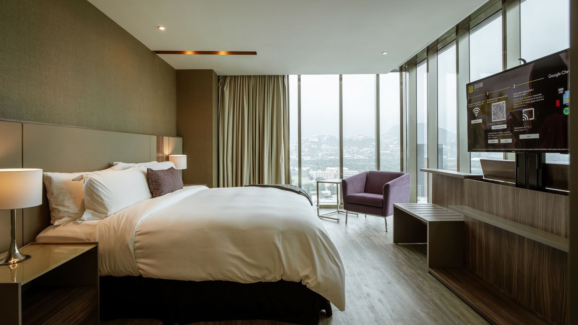 King Junior Suite with panoramic city views, purple chair and flat screen TV at Camino Real Fashion Drive, Monterrey