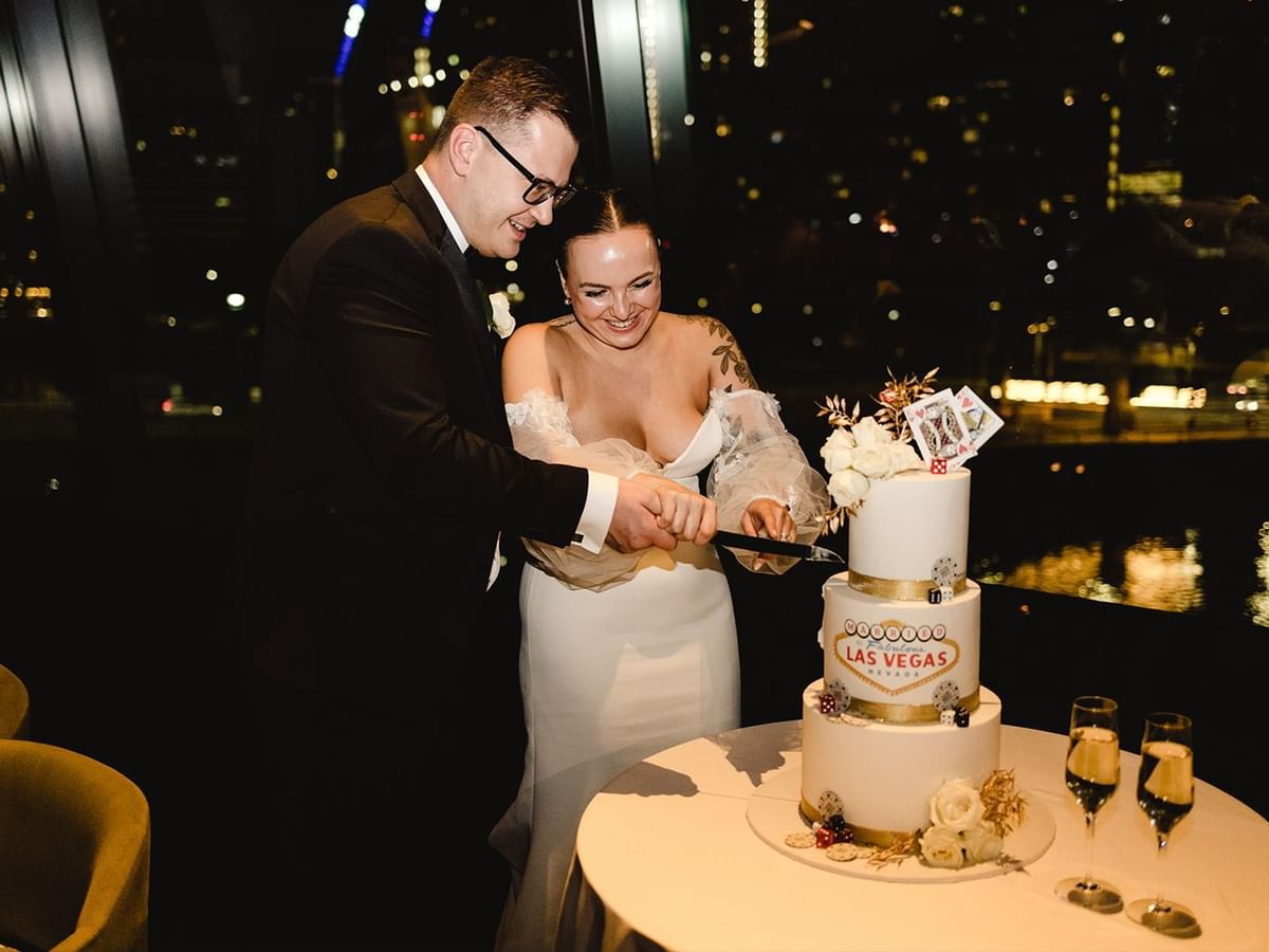 Valeriya and Mikhail cutting a Las Vegas-themed wedding cake at Crown Towers Perth