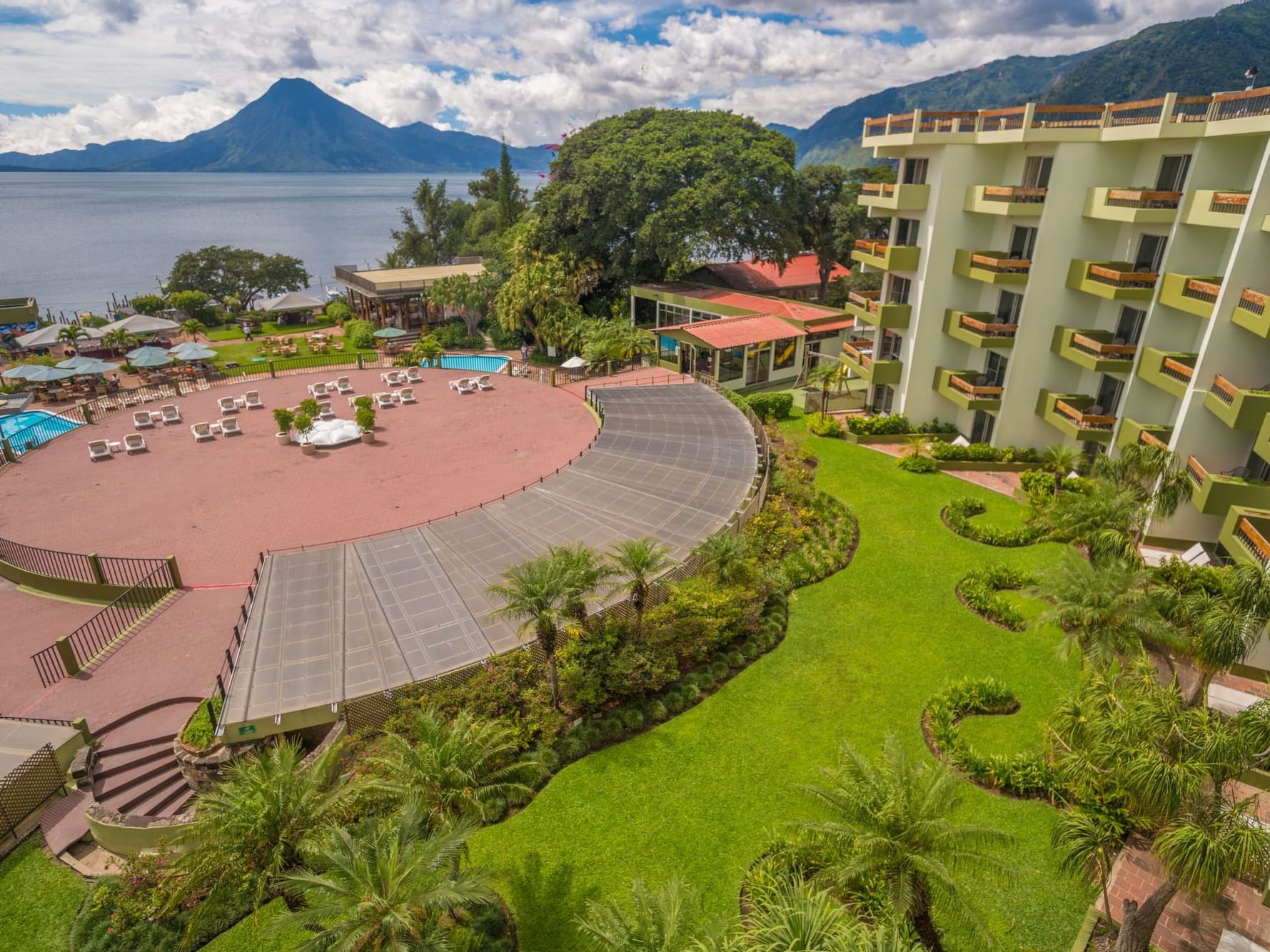 Distant view of the hotel & outdoor loungers overlooking the sea at Porta Hotel del Lago