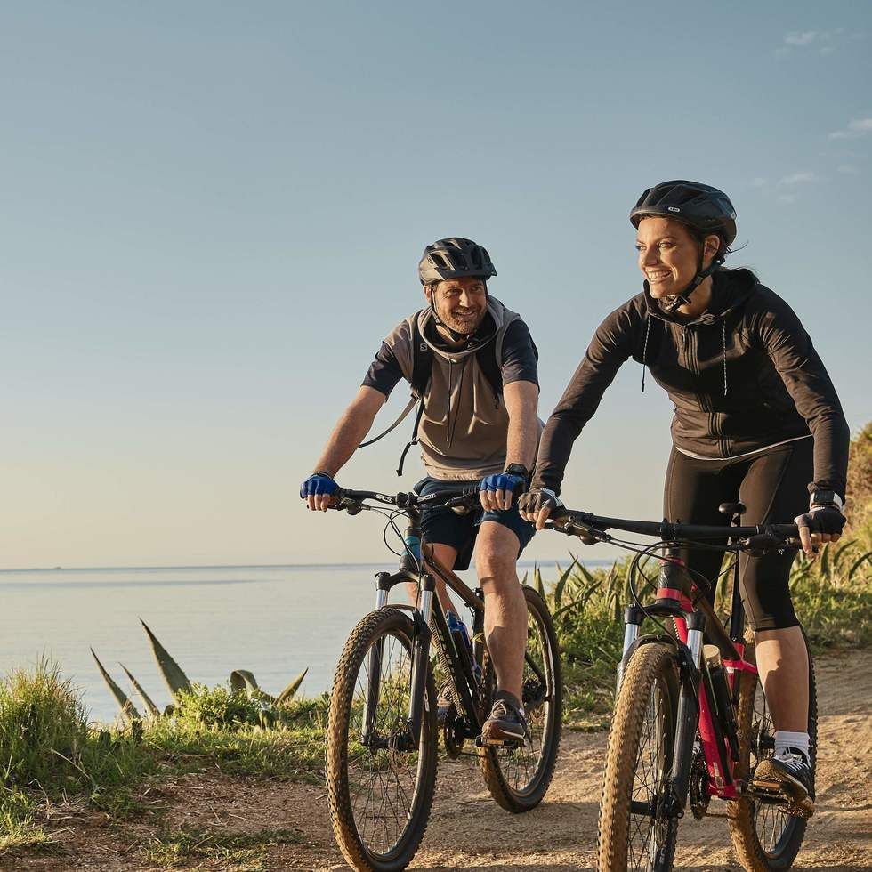 Two cyclists on mountain bikes by the sea at Falkensteiner Hotel & Spa Jesolo