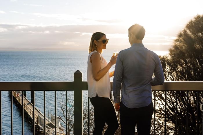 Couple enjoying wine on the terrace overlooking the lake at Freycinet Lodge