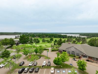 High-angle view of a parking lot by a resort clubhouse surrounded by green trees at Rodd Brudenell River Resort