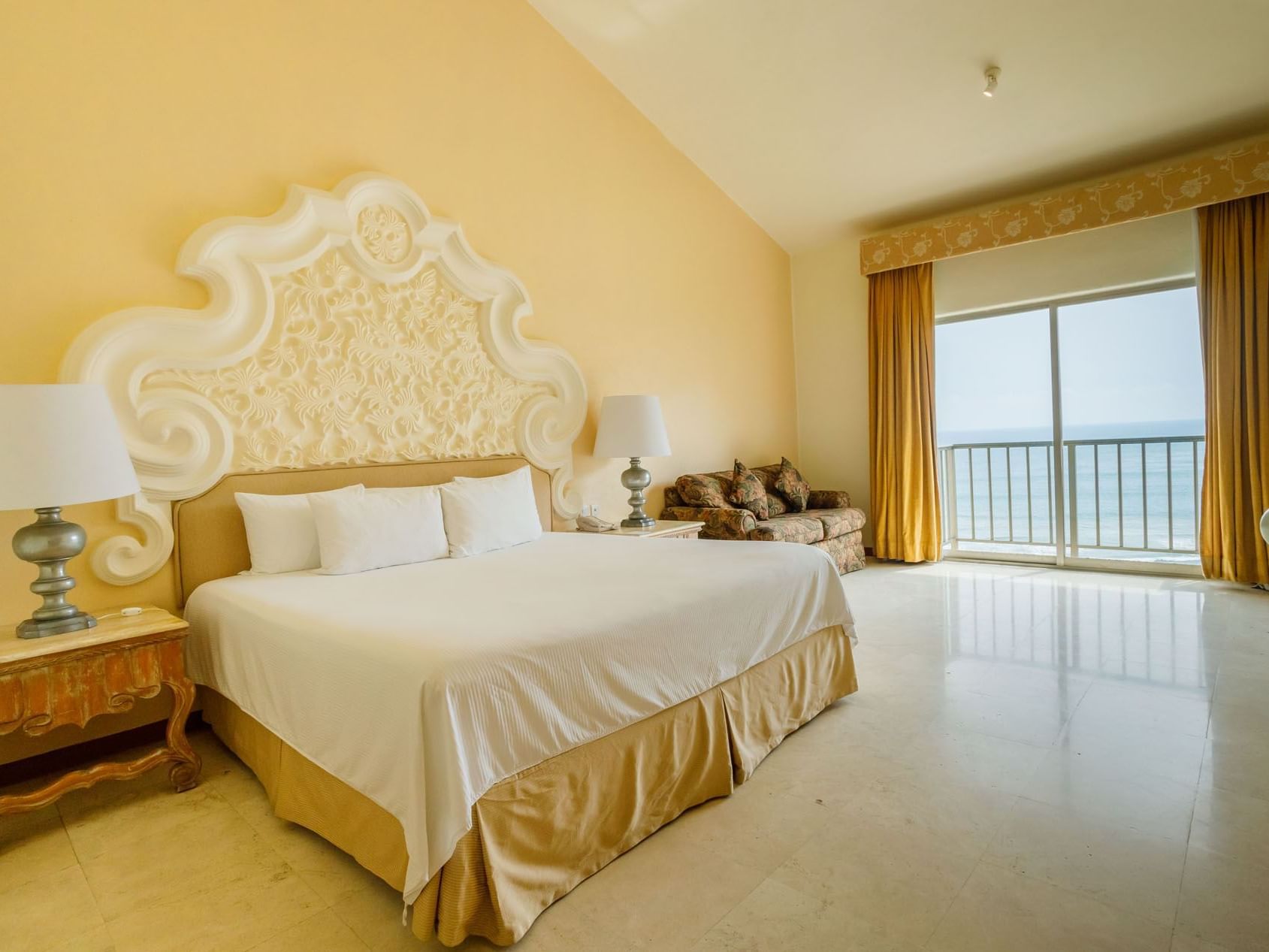 Sun-drenched King Grand Class showcasing a grand bed and sliding doors to the seaside at Quinta Real Acapulco