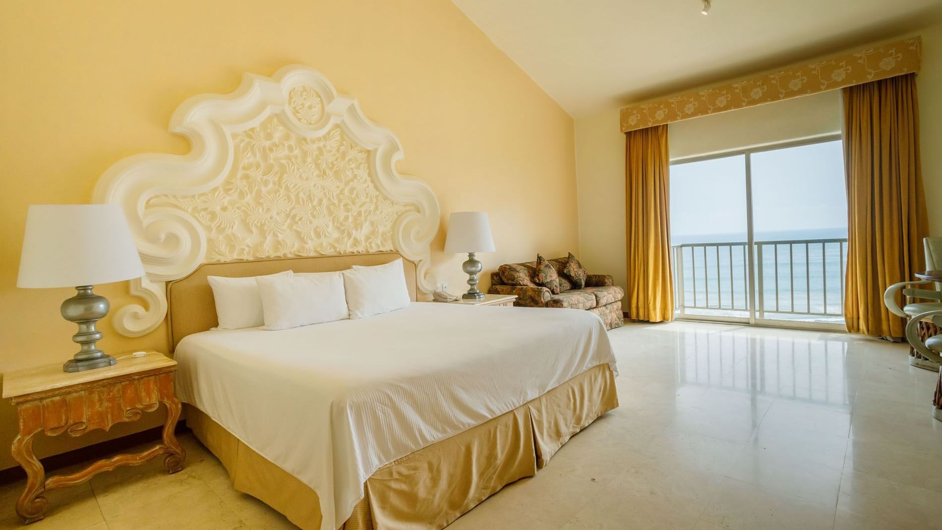 Sun-drenched King Grand Class showcasing a grand bed and sliding doors to the seaside at Quinta Real Acapulco