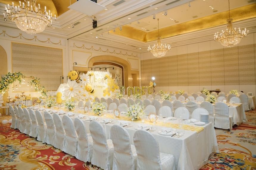 Elegant banquet hall decorated for a bee-themed celebration with tables featuring flowers & yellow accents, Park Hyatt Saigon