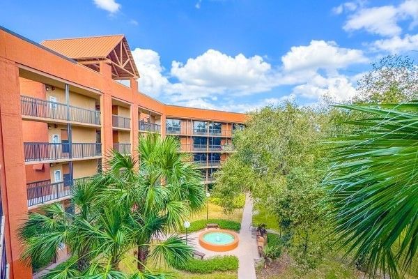 The exterior of Rosen Inn Lake Buena Vista with surrounding palm trees and a fountain.
