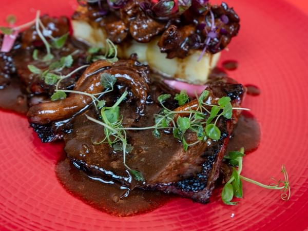 Pluma de cochon ibérique laqué au miel et soja, poêlée de girolles, mille-feuille de pommes de terre et jus corsé