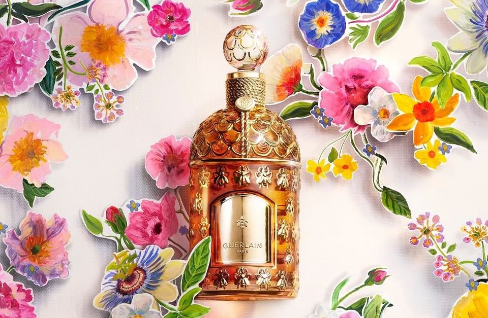 Guerlain perfume bottle surrounded by colorful paper flowers and floral illustrations at Hotel X Toronto
