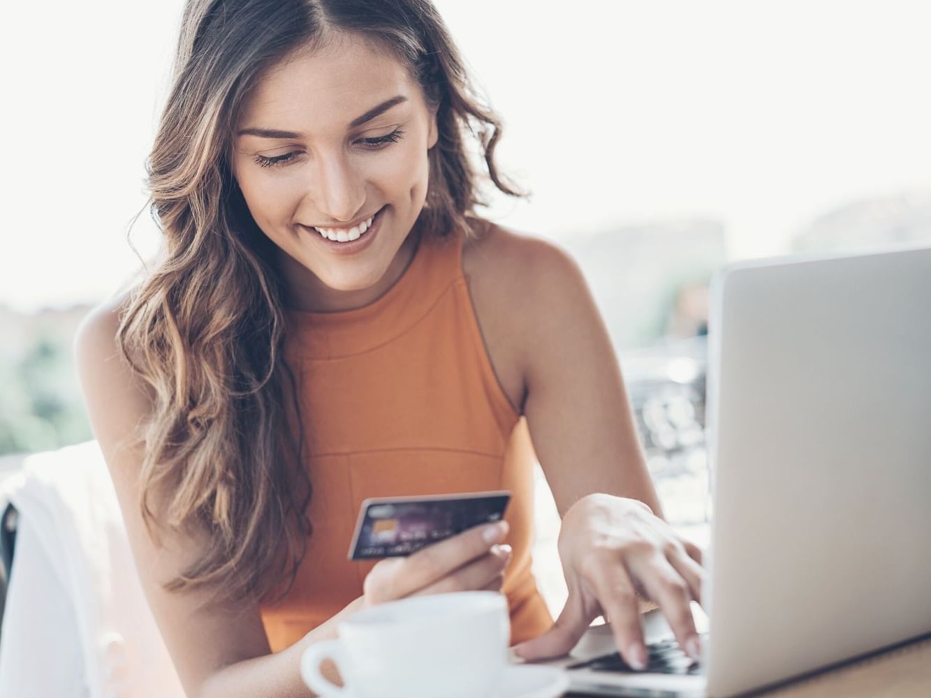 Woman using a laptop and holding a credit card at Waikiki Resort Hotel