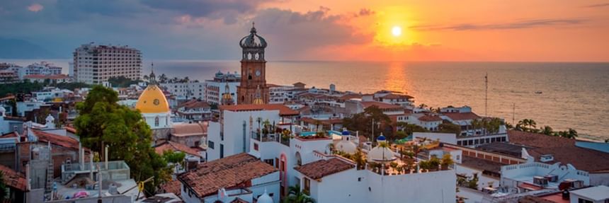 Scenic panoramic view of coastal city skyline with Our Lady of Guadalupe Church during a golden sunset near Casa Dona Susana