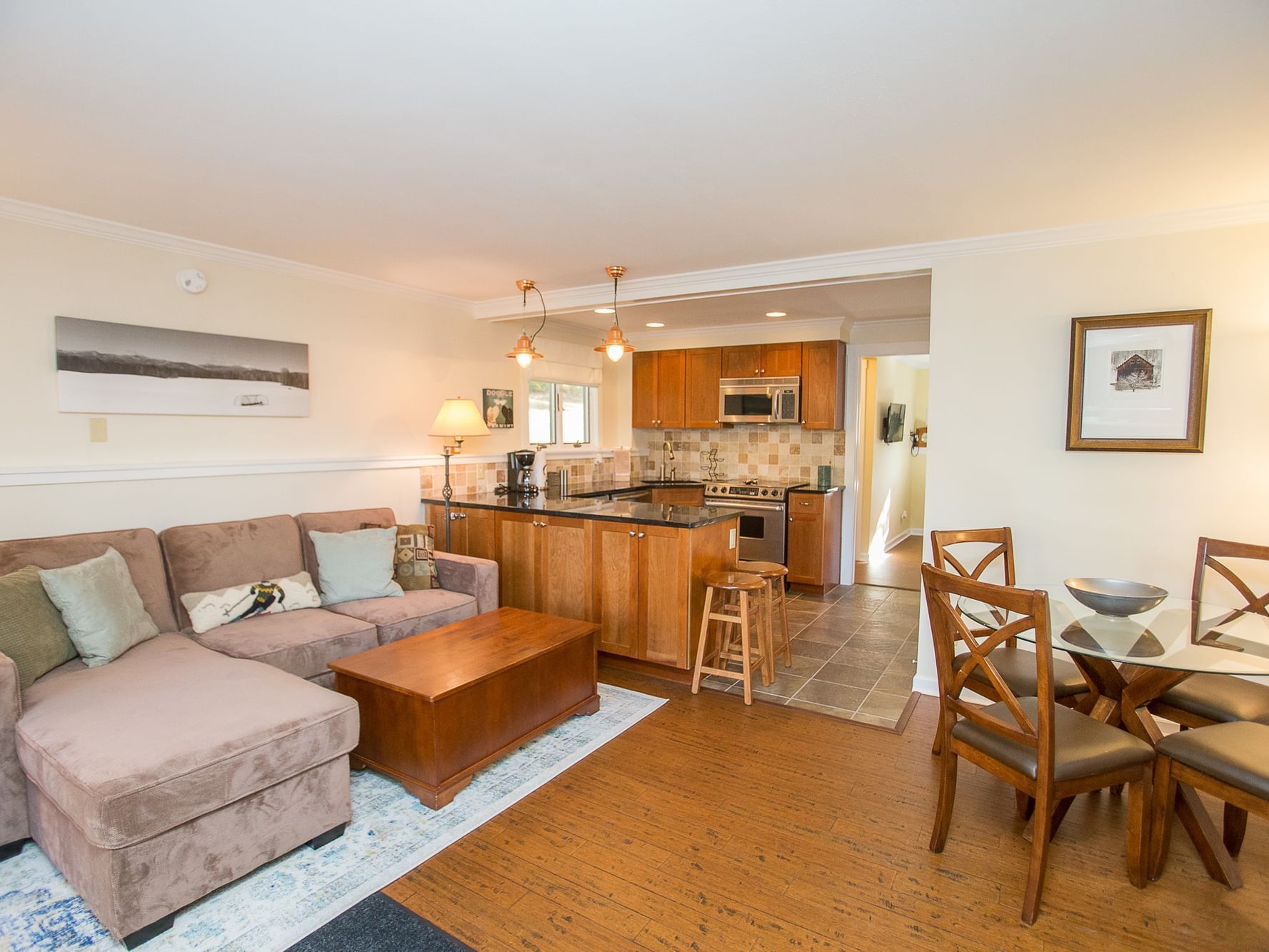 Open-concept living area with sectional sofa, dining table, and kitchen in Resort Home 466 at Topnotch Stowe Resort.