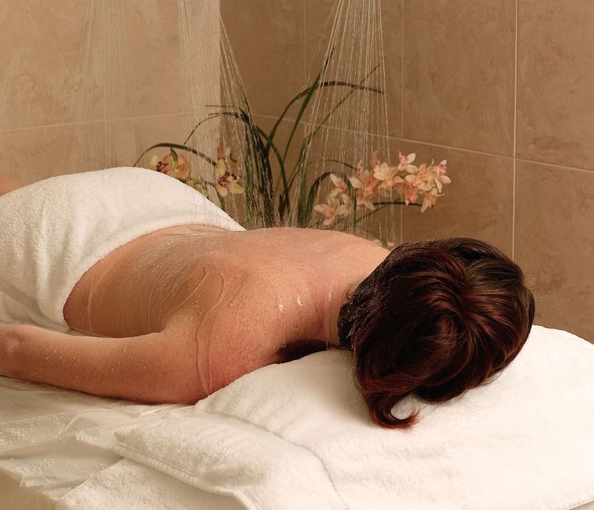 Lady receiving a soothing shower treatment on a massage table in The Regency Spa at Portland Regency Hotel & Spa