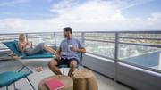 Couple lounging on the balcony of Intracoastal Room at Diplomat Beach Resort