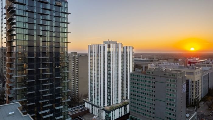 A white-coloured building within a neighbourhood of apartment towers and university buildings.